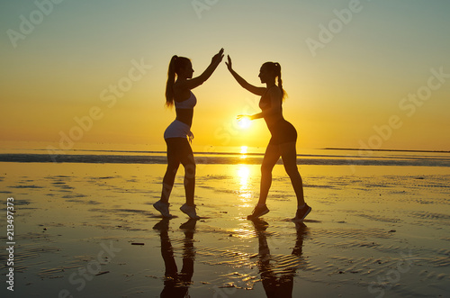 Silhouette two woman practicing yoga poses