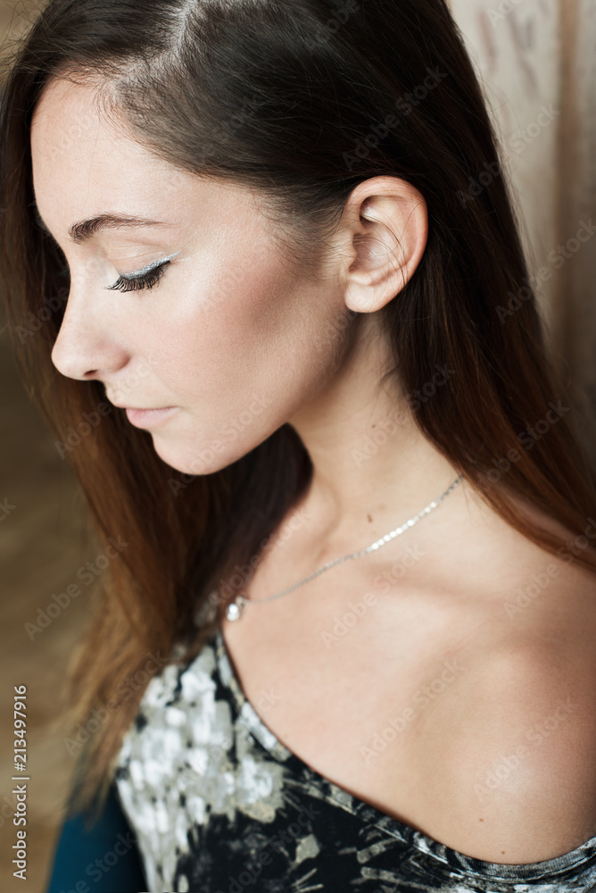 Portrait of young stylish pretty woman with long dark hair. Close up portrait of a beautiful girl with a clean fresh face looks aside. Fashion style. Portrait of young stylish pretty woman with long dark hair. Close up portrait of a beautiful girl with a clean fresh face looks aside. Fashion style.