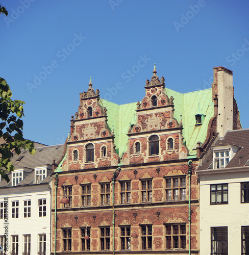 Copenhagen, Denmark - facades in Dutch Renaissance style of a building in city center with the green copper roof cover characteristic of the city profile
