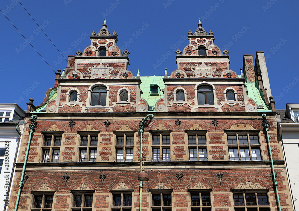 Copenhagen, Denmark - facades in Dutch Renaissance style of a building  in city center  with the green copper roof cover characteristic of the city profile