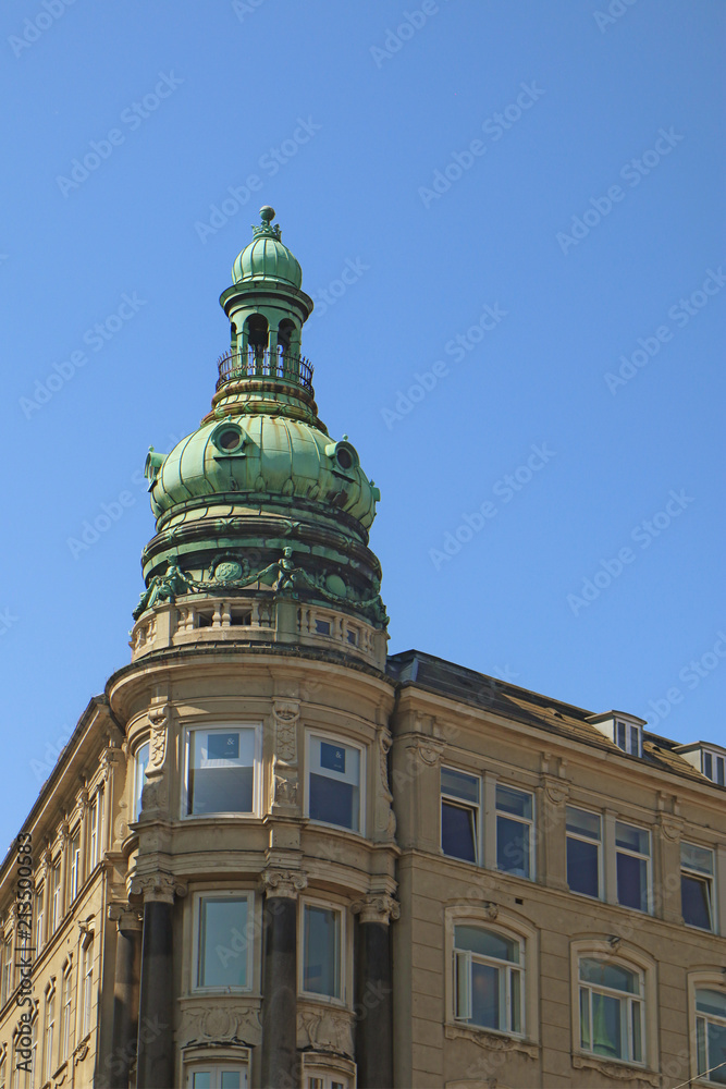 Copenhagen, Denmark - view of  an antique building tower in city center with the green copper decorated cover characteristic of the city profile
