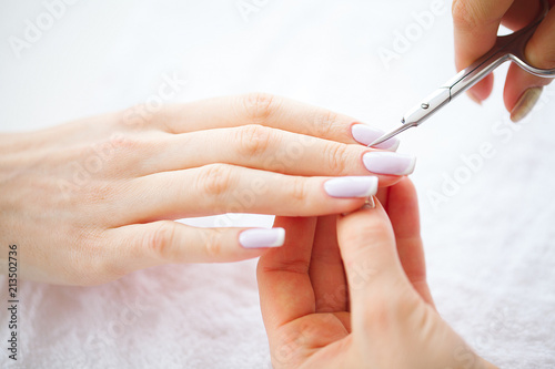 SPA manicure. French manicure at spa salon. Woman hands in a nail salon receiving a manicure procedure. Manicure procedure