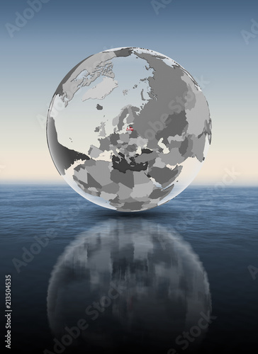 Latvia on translucent globe above water
