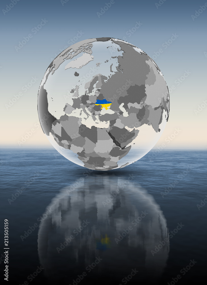 Ukraine on translucent globe above water Ukraine on translucent globe above water