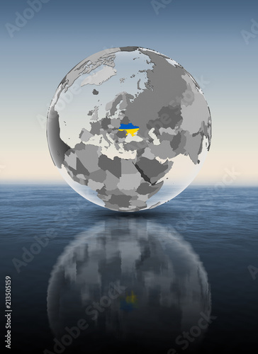 Ukraine on translucent globe above water