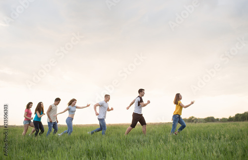 Group of people running in the grass,