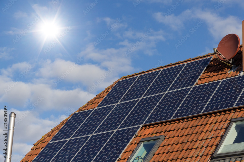 Fototapeta premium Solar panels on a house roof as a source of clean renewable energy.
