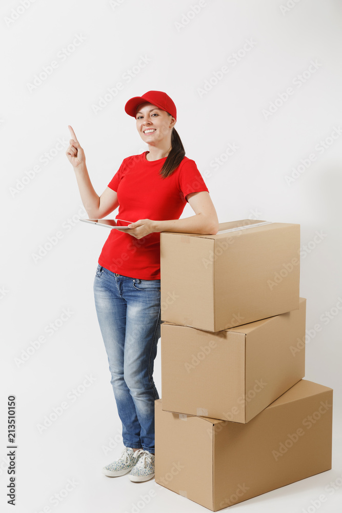 Full length portrait of delivery young woman in red cap, t-shirt isolated on white background. Female courier standing near empty cardboard boxes with tablet pc computer. Receiving package. Copy space Full length portrait of delivery young woman in red cap, t-shirt isolated on white background. Female courier standing near empty cardboard boxes with tablet pc computer. Receiving package. Copy space
