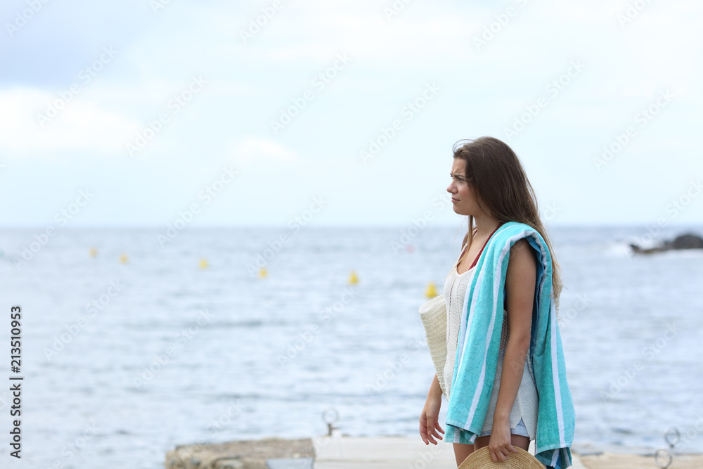Frustrated sunbather on the beach in a cloudy day Frustrated sunbather on the beach in a cloudy day
