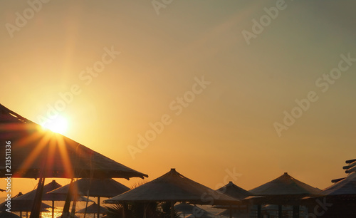 sunset between umbrellas on the coast of Izmir aegean sea