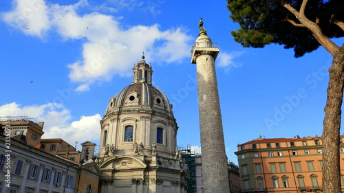 Trajanssäule steht neben Kirche nahe dem Forum Romanum vor blauem Himmel photo
