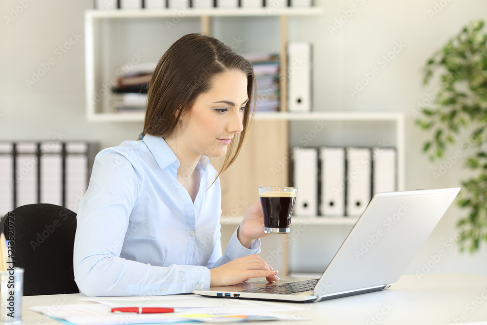 Office worker working online holding a coffee cup Office worker working online holding a coffee cup