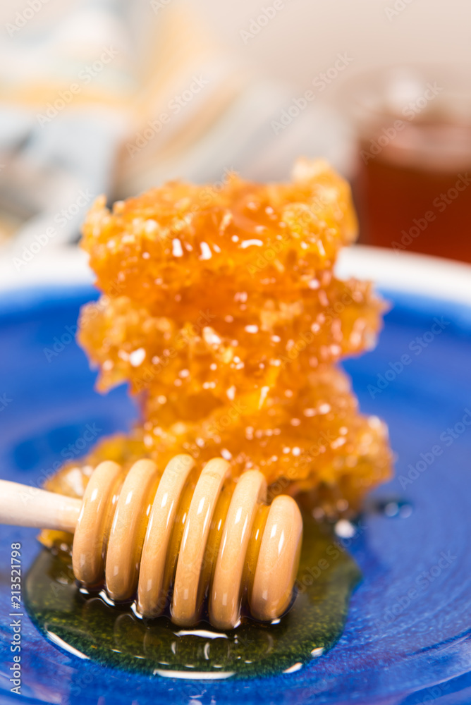 Honey Dipper Lays In Front of Stacked Honey Comb Honey Dipper Lays In Front of Stacked Honey Comb