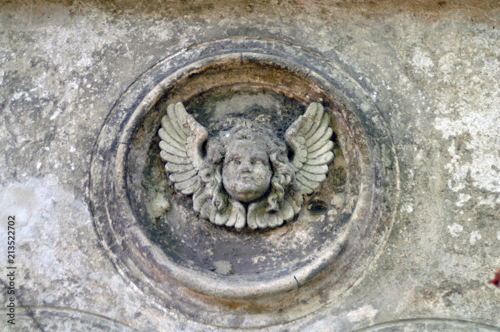 Weathered sandstone sculpture of an angel on a tomb of a cemetery in Berlin-Germany 