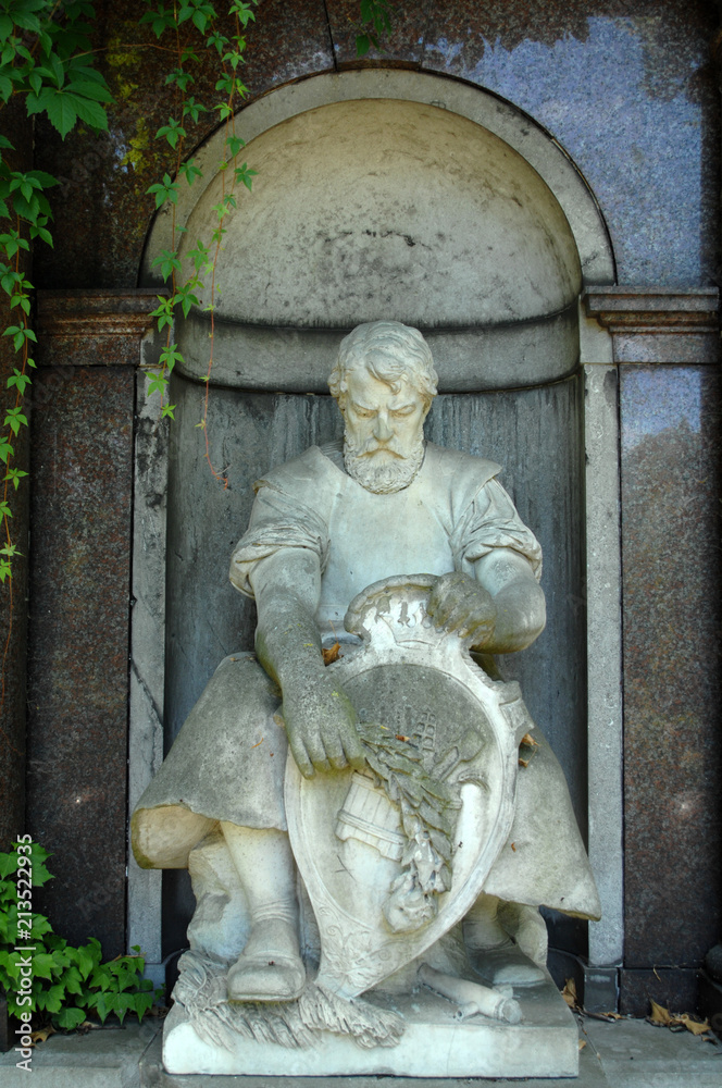 Weathered sculpture of a poet on a tomb of a cemetery in Berlin-Germany