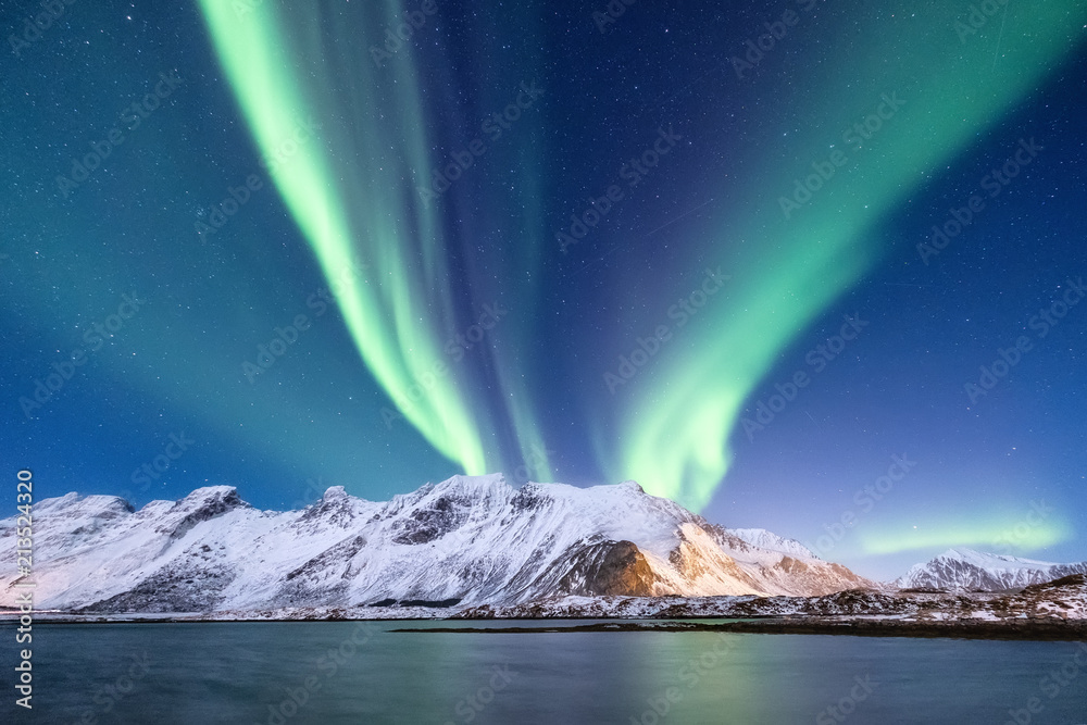 Northen light above mountains and ocean. Beautiful natural landscape in the Norway