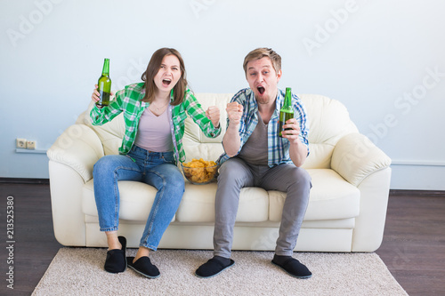 Soccer world cup concept - Couple of friends sitting in sofa watching sport game on tv © satura_