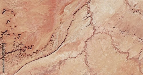 Very high-altitude overflight aerial of rocky desert, Monument Valley, Arizona and Utah. Clip loops and is reversible. Elements of this image furnished by USGS/NASA Landsat photo