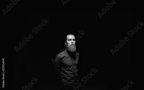 A male standing in the black background.  © Micko1986