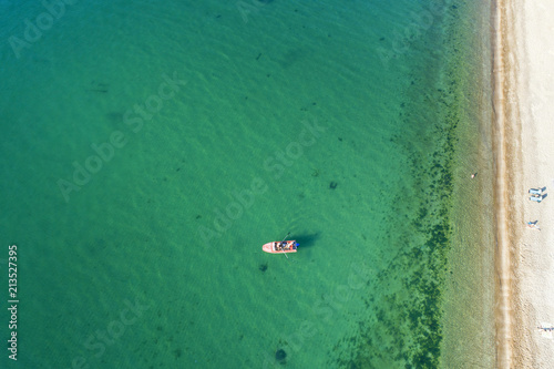 aerial view to alone boat in emerald water