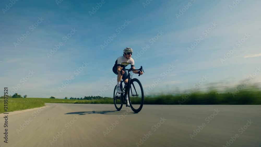 Close up tracking shot of a single man cyclist on the countryside road Close up tracking shot of a single man cyclist on the countryside road