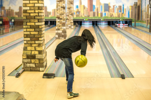 woman playing bowling throws a ball on the strip