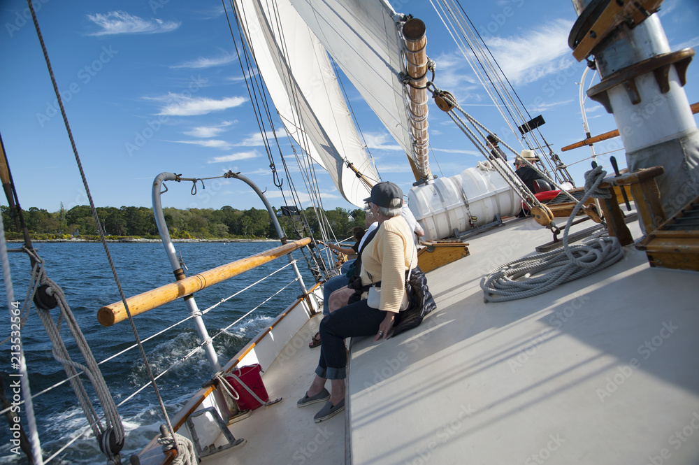 Obraz premium Schooner Sailboat Heeling from Wind Gust As Tourists Hold On