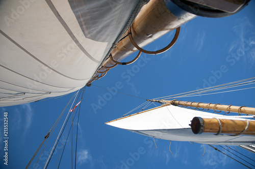 Full Sails on Wooden Masts of Saliboat with Blue Sky photo