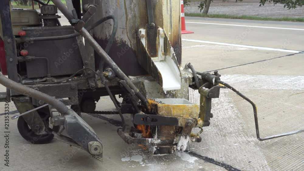Outdoor working : Man using machine to make traffic line stripe on the road Outdoor working : Man using machine to make traffic line stripe on the road
