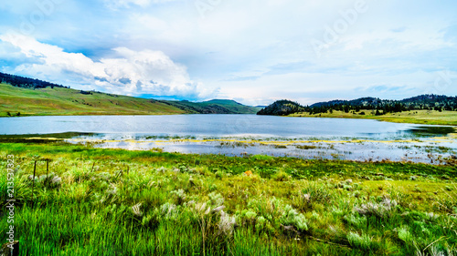 Stump Lake surrounded by the Rolling Hills and wide open Grass Lands of the Nicola Valley along Highway 5A, between Merritt and Kamloops, British Columbia, Canada, under partly cloudy sky photo