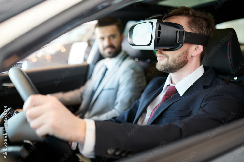 Bearded businessman wearing googles of virtual reality and imagining he is driving a car