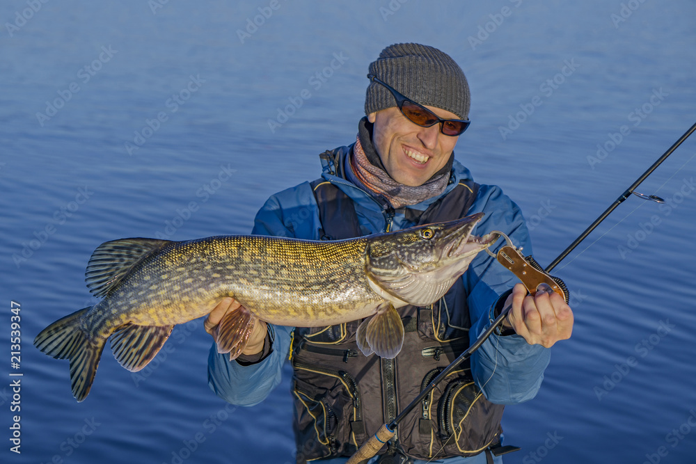 Fishing. Happy fisherman with big pike fish trophy Fishing. Happy fisherman with big pike fish trophy