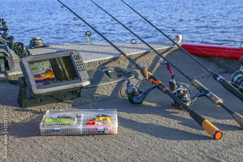 Fishing tackle set and fishfinder, echolot, sonar at the boat. Spinning rods with reels and lures photo