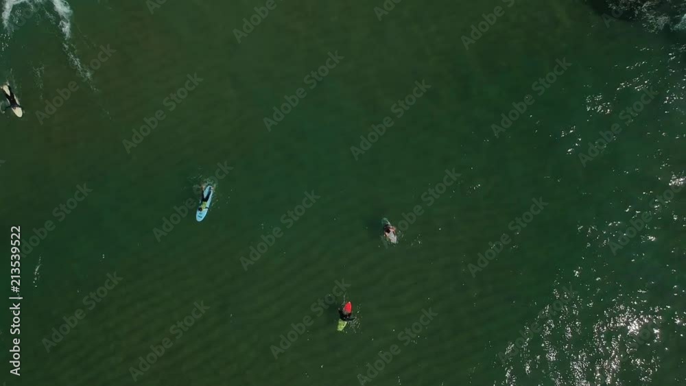 Aerial view of surfers in the ocean on a summer day. Surf Spot on the Portuguese coastline. Drone shot. Aerial view of surfers in the ocean on a summer day. Surf Spot on the Portuguese coastline. Drone shot.