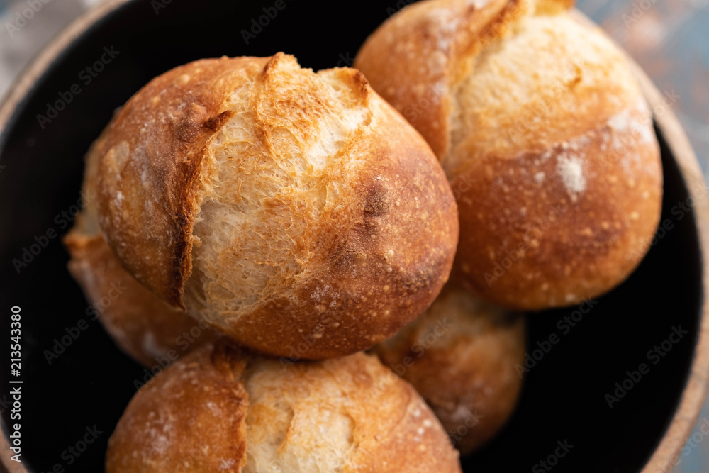 Fresh bread in a black bowl. Copy space. French bread. Fresh rolls.