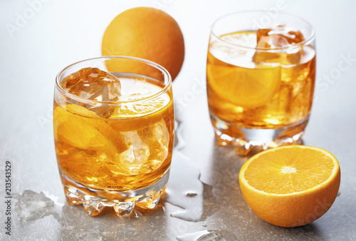 two glasses of orange cocktails on gray background