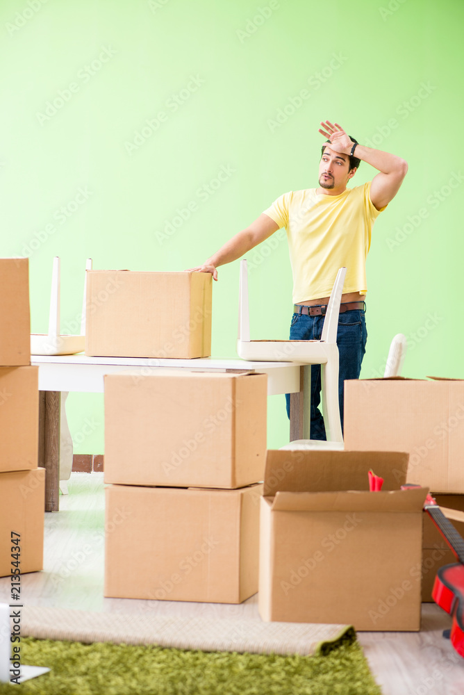 Young handsome man moving in to new house with boxes Young handsome man moving in to new house with boxes