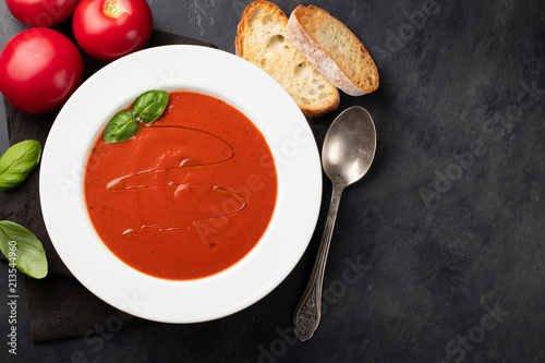 Fotografie Homemade tomato soup with Basil, toast and olive oil on the stone table