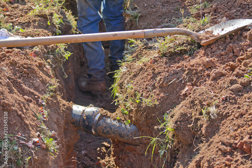 Digging Up an Underground Pipe With a Shovel