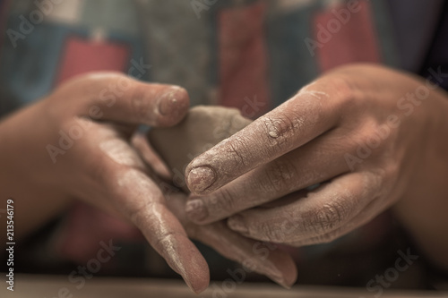 Female potter works with clay, craftsman hands close up with selective focus
