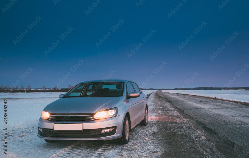 Naklejka premium Car Sedan In Country Road At Winter Evening