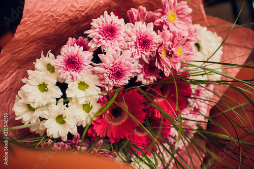 Blogger girl holding bunch of flowers at the flower market. Blogging concept. photo