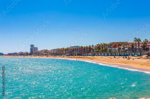 Barceloneta beach in Barcelona. Nice sand beach with palms. Sunny bright day with blue sky. Famous tourist destination in Catalonia, Spain photo