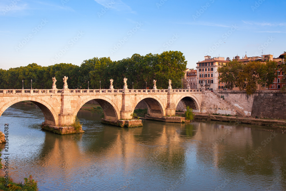 Panorama cityscape from the ancient embankment Tiber in Roma at sunset. Near of bridge and castle of Angels. Saint Angelo castle and bridge is famous tourist destination in Italy