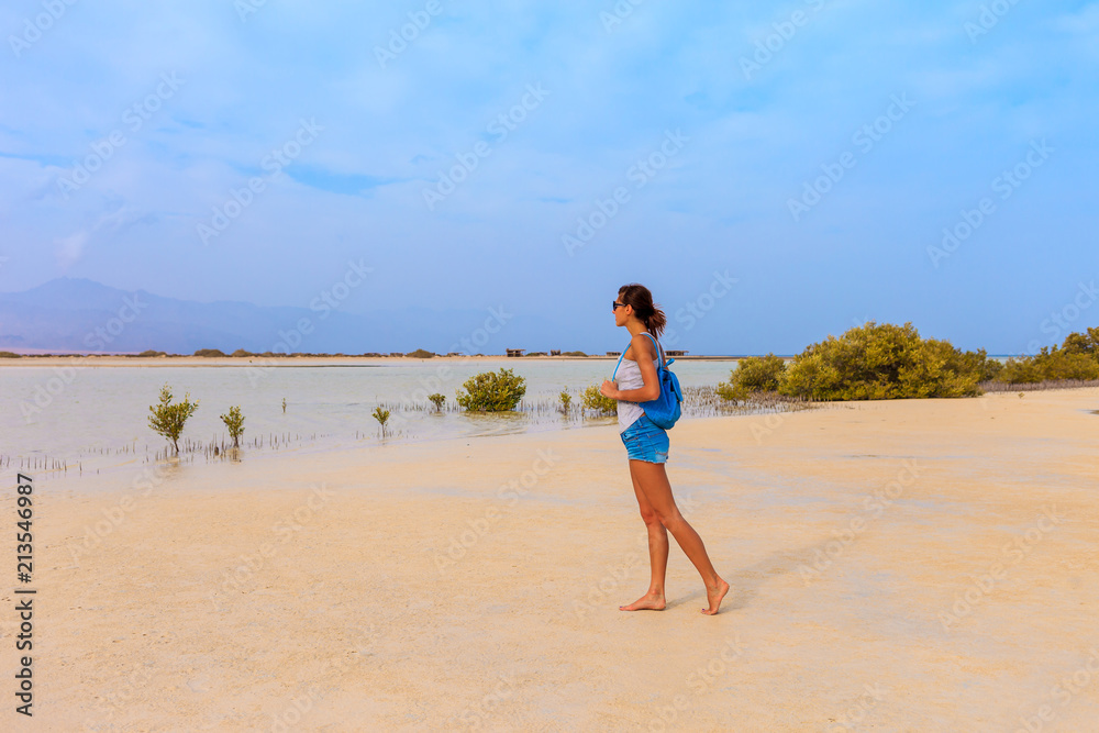 Tourist woman at the Red Sea coast and mangroves in the Ras Mohammed National Park. Famous travel destionation in desert. Sharm el Sheik, Sinai Peninsula, Egypt.