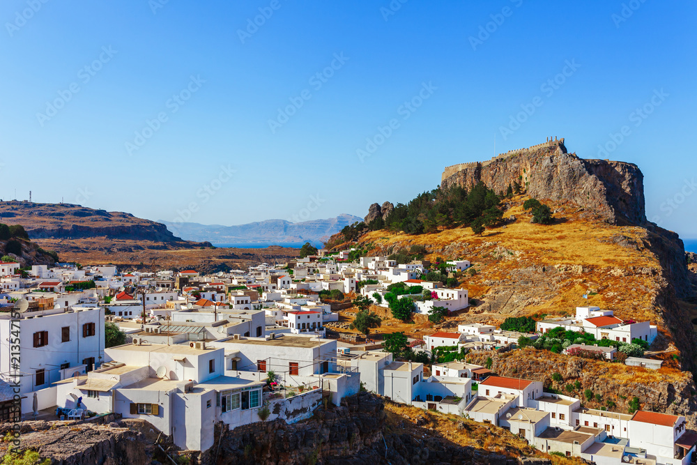 Skyview landscape photo Lindos town and ancient castle on Rhodes island, Dodecanese, Greece. Panorama with mountains and sea. Famous tourist destination in South Europe