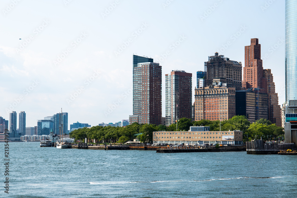 Naklejka premium New York City / USA - JUL 14 2018: Lower Manhattan Skyline view from Governors Island ferry on a clear afternoon