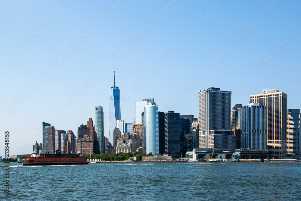 New York City / USA - JUL 14 2018: Lower Manhattan Skyline view from Governors Island ferry on a clear afternoon
