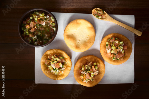 Chilenische Sopaipillas, herzhaftes frittiertes Gebäck aus Hefeteig, mit Chilenische Pebre aus Tomaten, Zwiebeln, Knoblauch, scharfe Paprika, Koriander und Petersilie photo