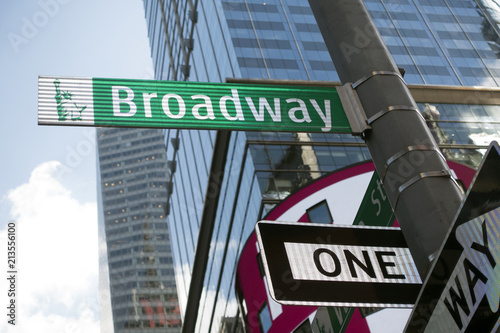 manhattan green white broadway street sign looking up, street lamp, day time